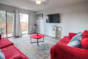 a living room with a red couch and a red table at Spacious 3BR, 2BA Condo near Medcenter & NRG in Houston