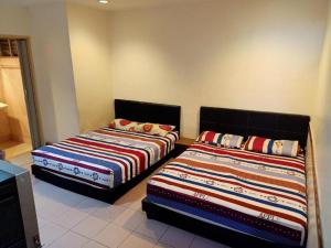 - deux lits assis l'un à côté de l'autre dans une pièce dans l'établissement OYO 90842 Hotel Prai Jaya, à Perai
