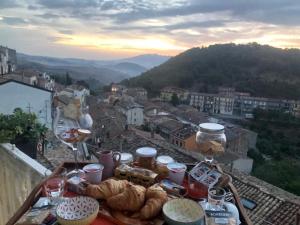 un tavolo con pane e bicchieri da vino e vista sulla città di La Vista a Calitri