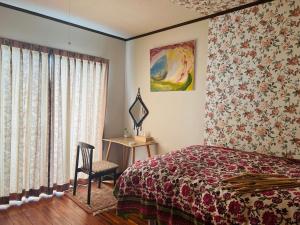 a bedroom with a bed and a chair and a window at Eishinan 栄進庵 in Fuji