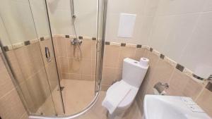 a bathroom with a toilet and a glass shower at VIP Apartments in Sozopol in Sozopol