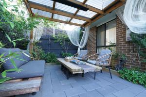 un patio con pérgola de madera, mesa y sillas en Fawkner Modern 3BR House Netflix WiFi Parking, en Melbourne