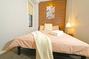 1 dormitorio con 1 cama con 2 toallas en Fawkner Modern 3BR House Netflix WiFi Parking, en Melbourne