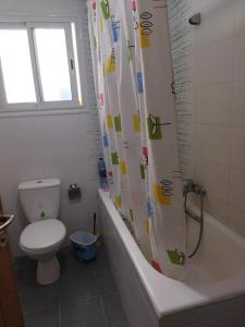 ein Badezimmer mit Toilette und Duschvorhang in der Unterkunft Yasmine appartement A7 in Nabeul
