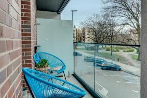 einen Balkon mit blauen Stühlen und Blick auf einen Parkplatz in der Unterkunft LM APARTAMENTY NARUTOWICZA Kamienica Nova 2-3 in Stettin