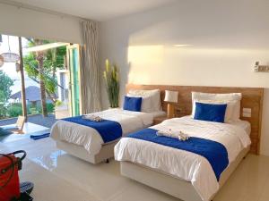 1 dormitorio con 2 camas con animales de peluche en Purana Resort Koh Yao Noi - SHA Extra plus, en Ko Yao Noi