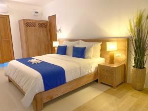 Purana Resort Koh Yao Noi - SHA Extra plus في كو ياو نوي: غرفة نوم بسرير كبير وملاءات زرقاء وبيضاء