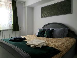 una camera da letto con un letto con un piumone e cuscini verdi di Enjoy BDF a Vatra Dornei
