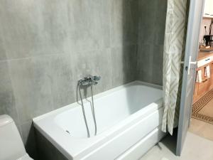 una vasca bianca in un bagno accanto ai servizi igienici di Enjoy BDF a Vatra Dornei