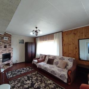 a living room with a couch and a television at Садиба "У стрийка" Сопіт in Sopot