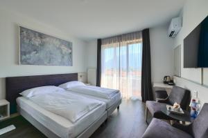 a bedroom with a bed and a large window at Hotel Luna Garni in Ascona