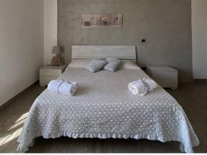 ein Schlafzimmer mit einem großen Bett mit zwei Handtüchern darauf in der Unterkunft Sweet Emma in Caserta