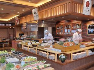 館山的住宿－千里風酒店，两名厨师在餐厅厨房准备食物