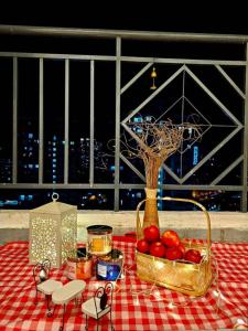 a picnic table with a basket of tomatoes and a vase at Soul Casa Homestay in Kuala Lumpur