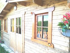a wooden house with a window on it at Jacuzzi Balnéo piscine "La Palmeraie Oasis" in Férolles