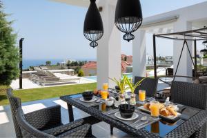 Koskinou的住宿－Villa La Bianca，露台上的桌子上摆放着食物和橙汁