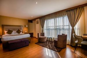 a hotel room with a bed and a large window at The Imperial Inn in Siliguri