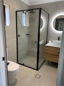 een badkamer met een douche, een toilet en een wastafel bij Old Maitland Inn in Maitland