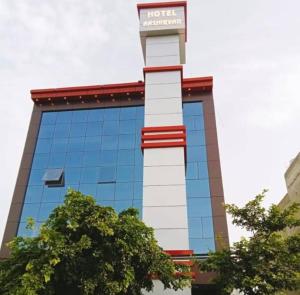 een hoog gebouw met een bord erop bij Flagship Hotel Aashirvad in Faridabad