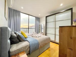 een slaapkamer met een bed en een groot raam bij KL Gateway 2B2B Cozy apartment in Kuala Lumpur
