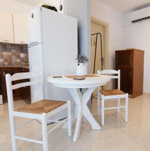 a white table and two chairs in a kitchen at Enada Suite & Olive Farm in Gythio