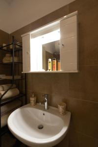 een witte wastafel in een badkamer met een spiegel bij Enada Suite & Olive Farm in Gythio