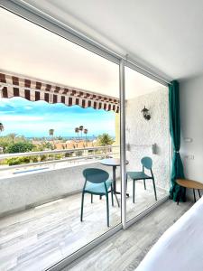 a bedroom with a balcony with a table and chairs at Borinquen Vista Mar in Playa de las Americas