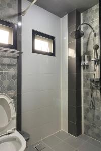 La salle de bains est pourvue d'une douche, de toilettes et d'un lavabo. dans l'établissement 44 Room Rama 3, à Bangkok