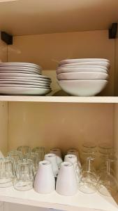 un estante lleno de platos y tazones en La villa De Lina 509 -Self Check In -, en Gallargues-le-Montueux