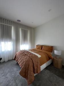 吉斯伯恩12 Stern Way New Gisborne的一间带大床和窗户的卧室