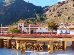 a view from the roof of a building with wooden tables and mountains at Hotel Inka Pisac in Pisac