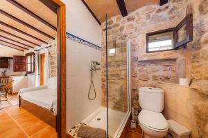 a bathroom with a toilet and a glass shower at Es Sestador in Petra +29 photos