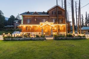 a large house with lights on the front of it at Shaw Inn by Stay Pattern in Gulmarg