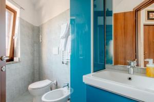 2 Bilder eines Badezimmers mit WC und Waschbecken in der Unterkunft La Parmigiana in Marino