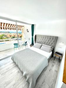 1 dormitorio con 1 cama grande y balcón en Borinquen Vista Mar en Playa de las Américas
