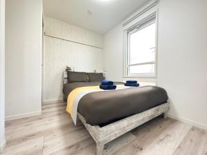 a bedroom with a large bed in a room with a window at nestay apartment tokyo waseda in Tokyo