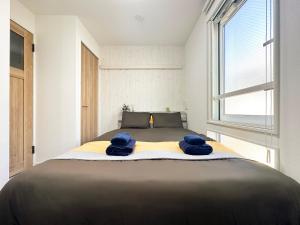 a bedroom with a bed with blue towels on it at nestay apartment tokyo waseda in Tokyo