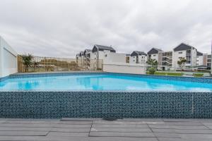 a swimming pool in front of some apartment buildings at Modern 3 Bedroom Near The Beachfront in Summerstrand