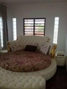 a bedroom with a large bed with a large tufted couch at Fiji-Beauty in Nadi