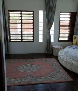 a bedroom with a bed and two windows and a rug at Fiji-Beauty in Nadi
