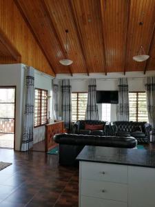 a living room with black leather furniture and wooden ceilings at Fiji-Beauty in Nadi