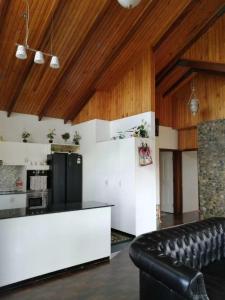 a kitchen with wooden ceilings and a black leather couch at Fiji-Beauty in Nadi