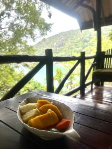 a bowl of vegetables sitting on a wooden table at Bambu Huts in Baan Tai