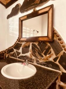 W łazience znajduje się umywalka i lustro. w obiekcie Bambu Huts w mieście Baan Tai