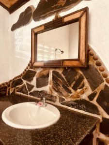 a bathroom with a sink and a mirror at Bambu Huts in Baan Tai