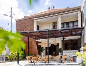 a patio with tables and chairs in front of a building at Tamantara in Ubud