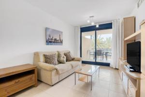 a living room with a couch and a television at Sueños de Denia in Denia