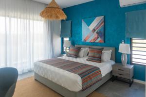 Schlafzimmer mit blauen Wänden und einem Bett mit Kissen in der Unterkunft Pearl Collection in Grand Baie
