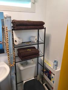 a bathroom with a shelf with towels and a toilet at Elisabeth Lodge Vairupe in Bora Bora