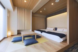 a bedroom with a large bed and a table at stayme THE HOTEL Asakusa Riverside in Tokyo